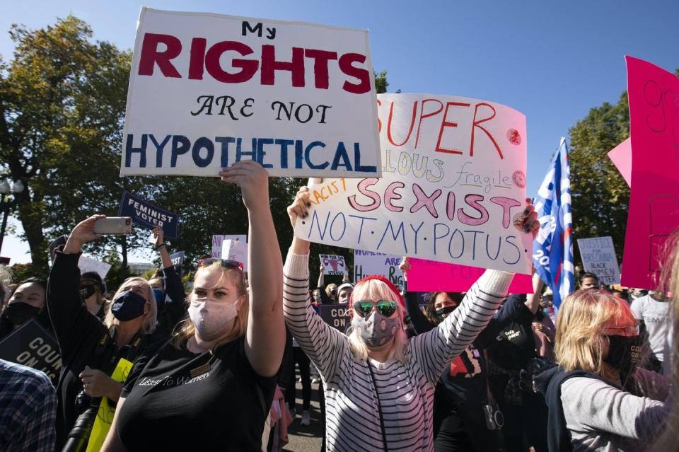 Demonstrators hold placards in front of the Supreme Court during the Women's March in Washington, D.C. The foremost sign reads: My rights are not hypothetical.