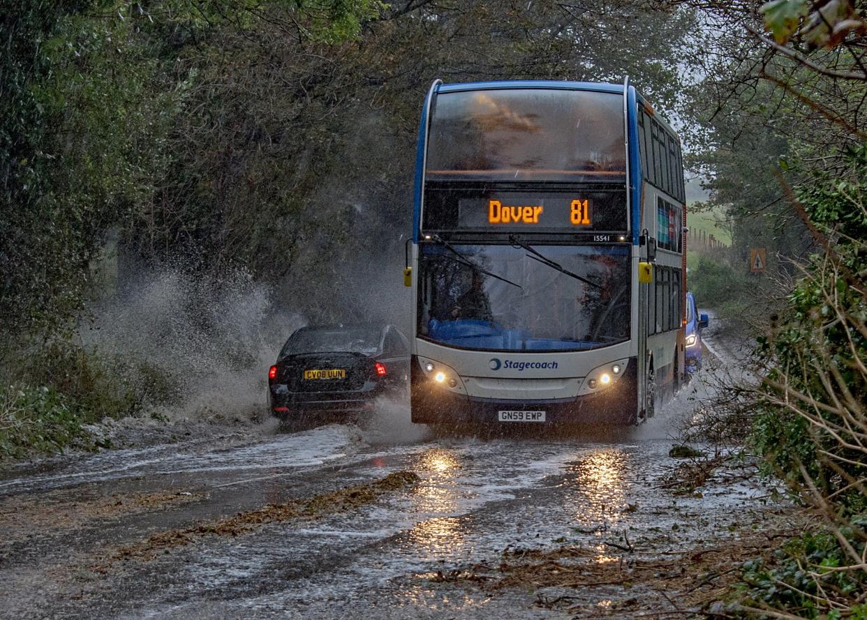 A bus makes its way through heavy rain and muddy roads during Storm Ciarán in Dover, England (EPA)