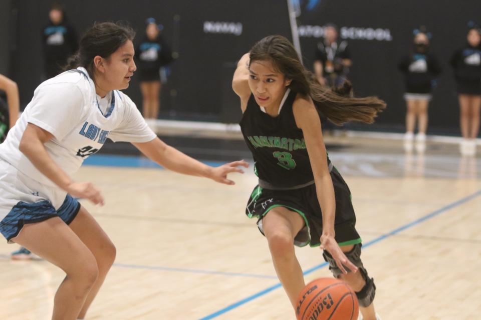 Farmington's Kamalani Anitielu (3) dribbles past Navajo Prep's Shiloh Conn (22) during the first quarter of their girls basketball game, Tuesday, Dec. 6, 2022 at the Eagles Nest.