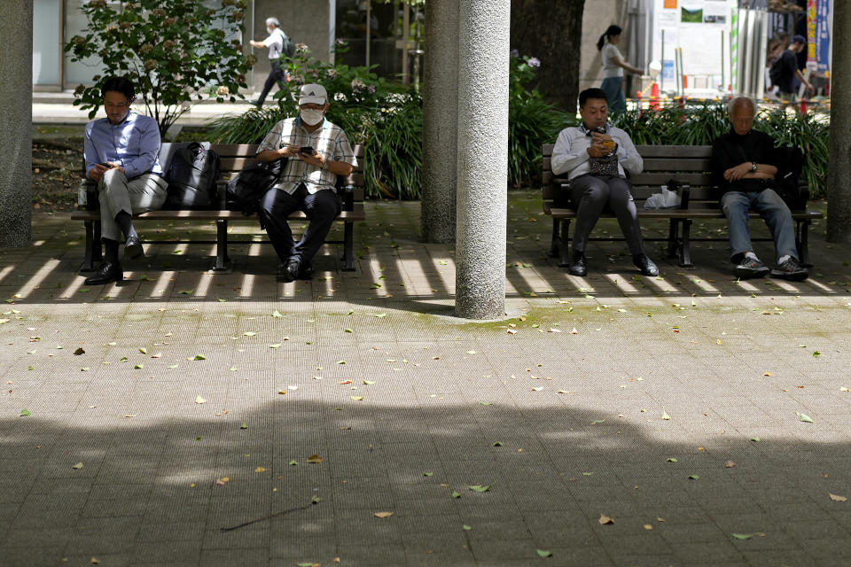 People rest in shade at a park in Tokyo, Friday, July 7, 2023, in Tokyo. Hot weather continues in the metro area as temperatures rise to 32 degrees Celsius (89 degrees Fahrenheit), according to Japan's meteorological bureau. (AP Photo/Shuji Kajiyama)
