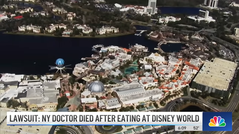 Aerial view of Disney World with a news banner about a NY doctor's death after eating there