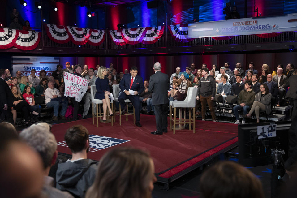 A protesters yells at Democratic presidential candidate former New York City Mayor Mike Bloomberg, right, during a FOX News Channel Town Hall, co-moderated by FNC's chief political anchor Bret Baier of Special Report and The Story anchor Martha MacCallum, at the Hylton Performing Arts Center in Manassas, Va., Monday, March 2, 2020. (AP Photo/Carolyn Kaster)