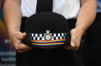 <p>A Met officer holds a police helmet sporting a rainbow ribbon as Belfast Gay Pride takes place on Aug. 5, 2017 in Belfast, Northern Ireland. (Photo: Charles McQuillan/Getty Images) </p>