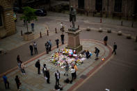 <p>People stand by flowers offered for the victims of a suicide attack at a concert by Ariana Grande that killed more than 20 people Monday night in central Manchester, Britain, Wednesday, May 24, 2017. (AP Photo/Emilio Morenatti) </p>