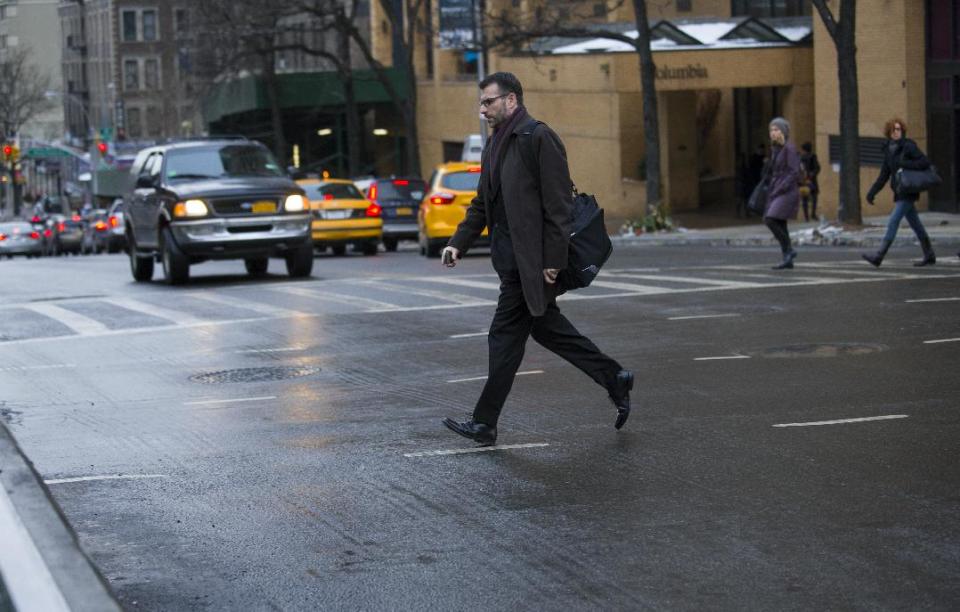 A Pedestrian moves quickly outside of a crosswalk at the busy intersection of W. 96th Street and Broadway in the Upper West Side of New York Monday, Jan. 27, 2014. Although it appears clear sometimes at this intersection, cars using turning lanes can quickly encroach on non-crosswalk areas. New York Mayor Bill de Blasio, in the wake of 11 pedestrian deaths in the city already in 2014, is taking direct aim at not just drivers but pedestrians, with a crackdown that has resulted in the first jaywalking tickets some residents have ever seen. (AP Photo/Craig Ruttle)