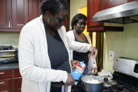 Ebele Azikiwe, 12, right, cooks with her mother, Rume Joy Azikiwe-Oyeyemi, at home in Cherry Hill, N.J., Wednesday, March 24, 2021. Ebele testified in October at state Assembly hearing, lending her support to legislation requiring New Jersey's school districts to add diversity to curriculums. Democratic Gov. Phil Murphy signed the bill into law. (AP Photo/Matt Rourke)