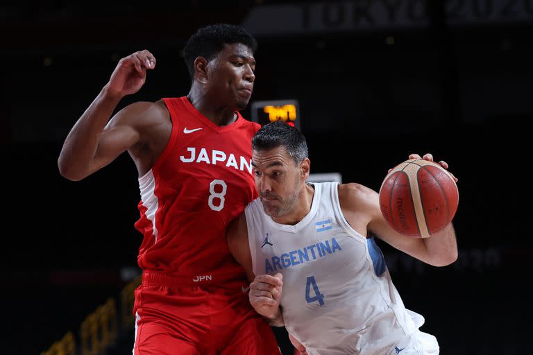 El argentino Luis Scola (derecha) corre con el balón ante el japonés Rui Hachimura en el partido de baloncesto del grupo C de la ronda preliminar masculina entre Argentina y Japón