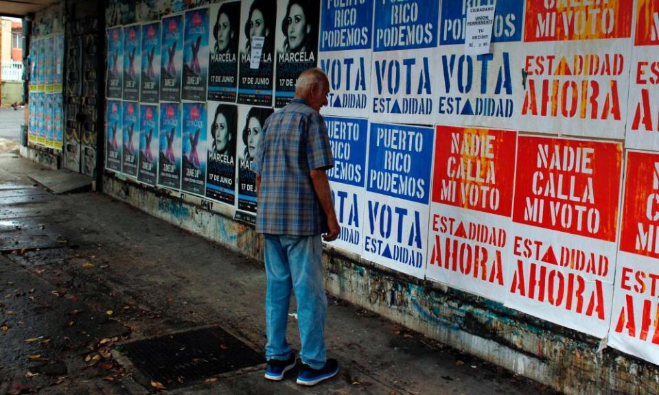 A man reads campaign posters in San Juan before the vote on Puerto Rican statehood.