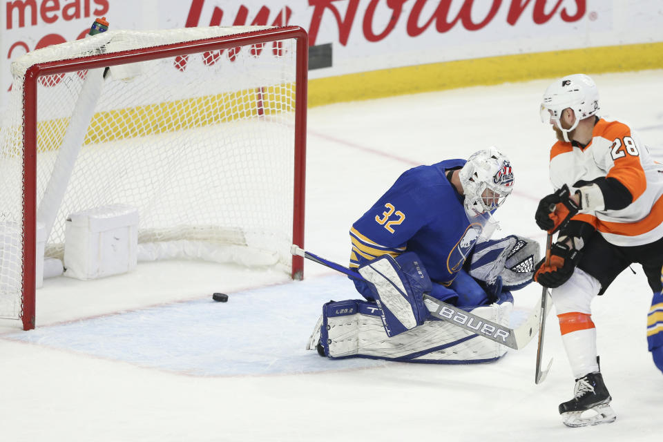 Philadelphia Flyers center Claude Giroux (28) scores through the legs of Buffalo Sabres goaltender Michael Houser (32) during the third period of an NHL hockey game Saturday, Jan. 22, 2022, in Buffalo, N.Y. (AP Photo/Joshua Bessex)