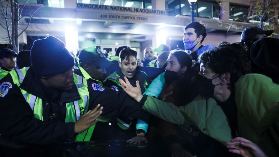 Police and demonstrators argue at the entrance to the Democratic National Headquarters during a multi-denominational event calling for a ceasefire in the conflict between Israel and Palestinian Islamist group Hamas, in Washington, DC. - Leah Millis/Reuters