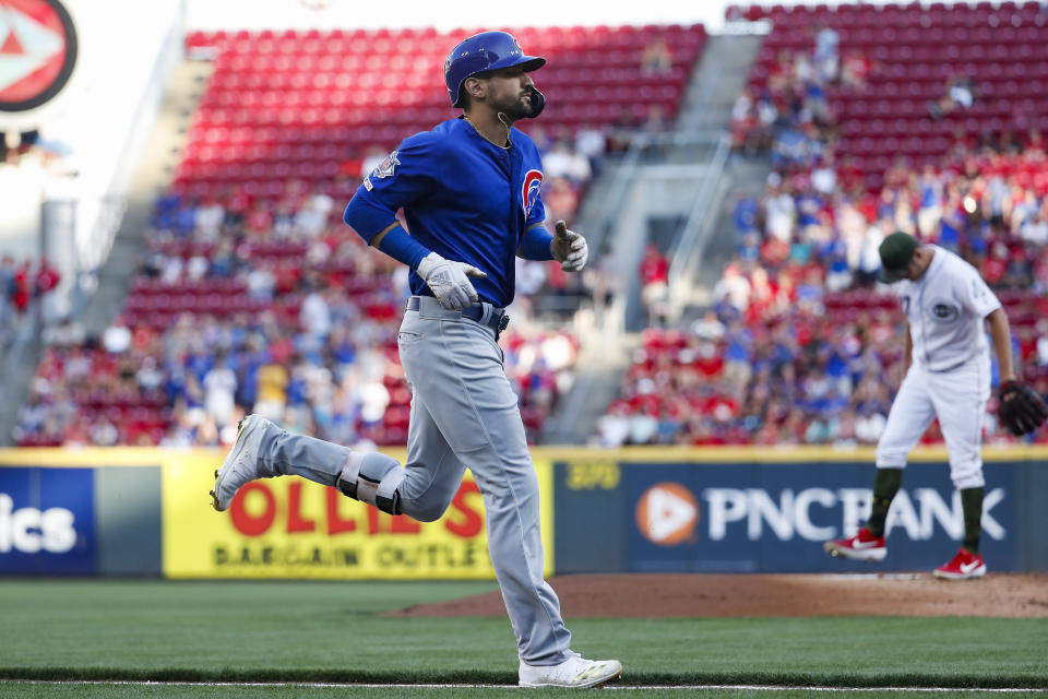 Chicago Cubs' Nicholas Castellanos runs the bases after hitting a solo home run off Cincinnati Reds starting pitcher Trevor Bauer, right, in the first inning of a baseball game, Friday, Aug. 9, 2019, in Cincinnati. (AP Photo/John Minchillo)