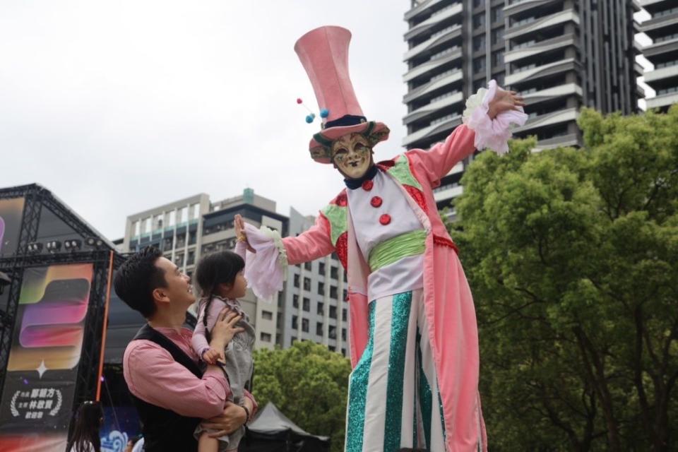 踩高蹻尋夢巨人彎身擊掌，鄭朝方市長帶動歡樂。（圖/記者黃溎芬翻攝）