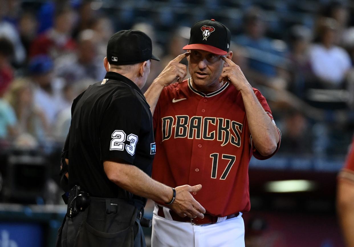 Manager Torey Lovullo #17 of the Arizona Diamondbacks talks with home plate umpire Lance Barksdale #23 after Nick Ahmed #13 with thrown out attempting to steal second base against the Chicago Cubs during the seventh inning at Chase Field on May 15, 2022 in Phoenix, Arizona.