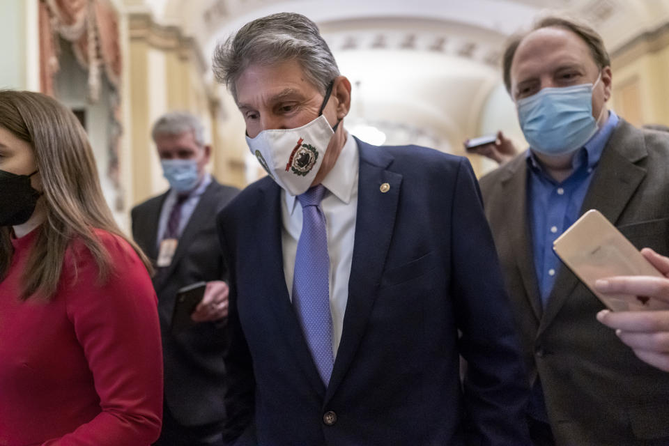 Democratic Sen. Joe Manchin of West Virginia, center, is surrounded by reporters as he walks to a policy luncheon at the Capitol in Washington, Tuesday, Nov. 16, 2021. The moderate, who is a key vote on President Joe Biden's domestic spending agenda, has used his leverage in the evenly divided Senate to whittle away some of his party's most ambitious and costly policy proposals. (AP Photo/J. Scott Applewhite)