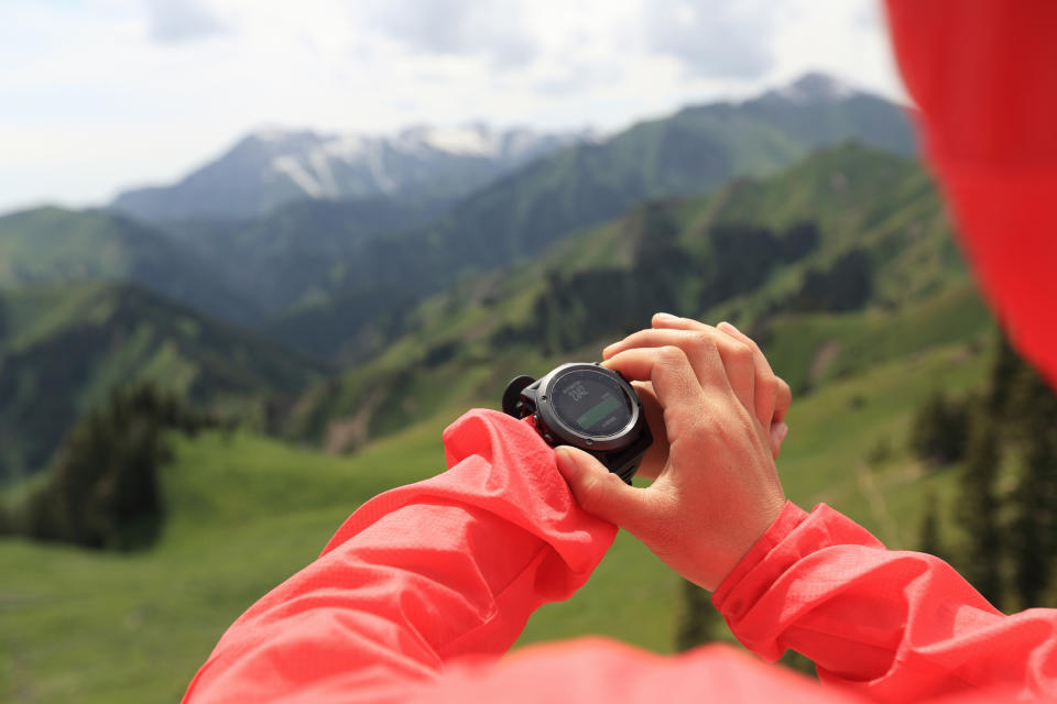 A hiker interacts with a GPS watch.