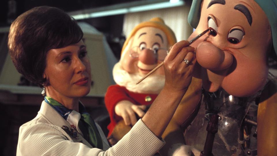 An Imagineer paints an animatronic dwarf