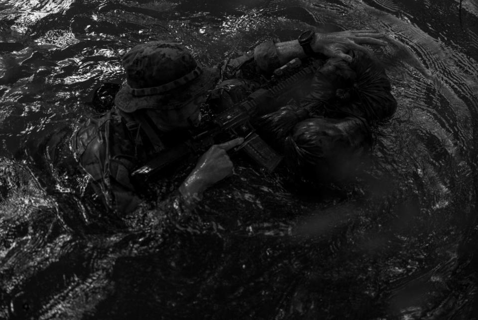 A Marine Raider with Marine Forces Special Operations Command traverses a river during a jungle mobility course, Aug. 4, 2023.