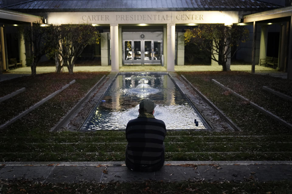 Royce Soble, of Atlanta, sits near a reflection pool at The Carter Center after former first lady Rosalynn Carter has died, Sunday, Nov. 19, 2023, in Atlanta. "I just wanted to sit here and share a moment of peace and say my respects for the family," Soble said. (AP Photo/Brynn Anderson)