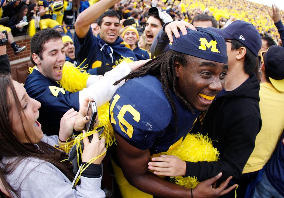 Denard Robinson of the Michigan Wolverines celebrates with students after beating Ohio State 40-34 at Michigan Stadium on Nov. 26, 2011 in Ann Arbor.