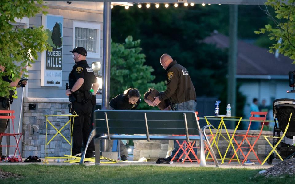 Evidence technicians comb through the scene