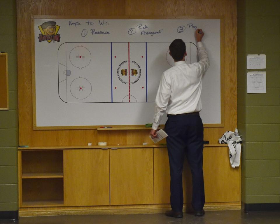 Erie Otters head coach Kris Knoblauch writes on the board before the Canada-Russia Series. 