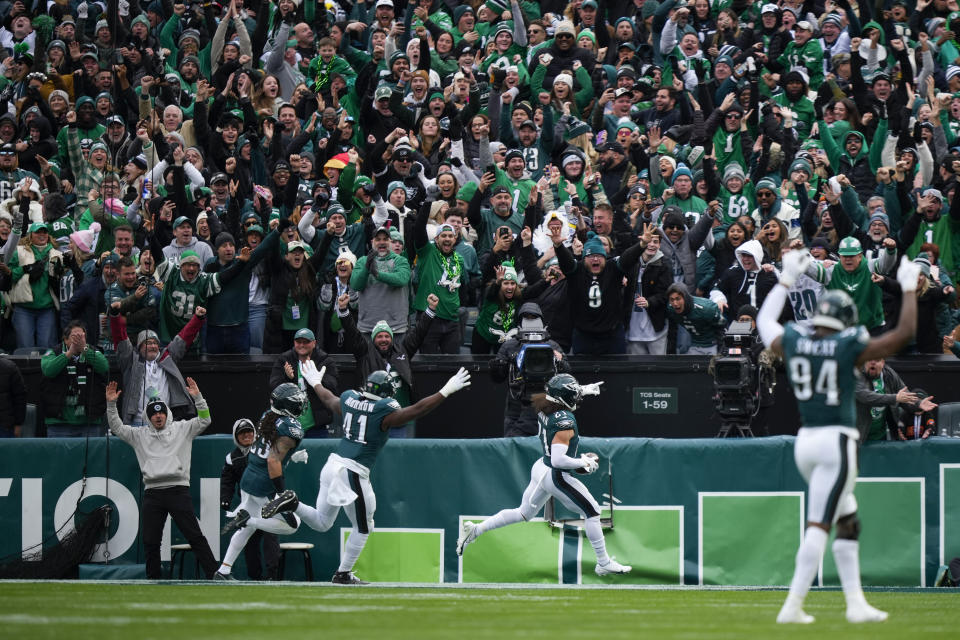 Spectators react along with Philadelphia Eagles linebacker Nicholas Morrow (41) and defensive end Josh Sweat (94) as safety Sydney Brown (21) scores on a long interception return against the Arizona Cardinals during the first half of an NFL football game, Sunday, Dec. 31, 2023, in Philadelphia. (AP Photo/Matt Slocum)