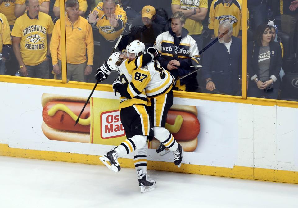 <p>Pittsburgh Penguins left wing Carl Hagelin (62) celebrates with center Sidney Crosby (87) after scoring an empty net goal against the Nashville Predators during the third period in Game 6 of the 2017 Stanley Cup Final at Bridgestone Arena. Mandatory Credit: Aaron Doster-USA TODAY Sports </p>