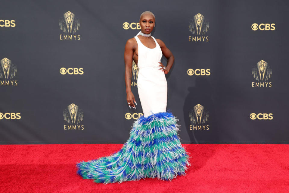 Cynthia Erivo on the red carpet in a white gown with a blue feathered bottom