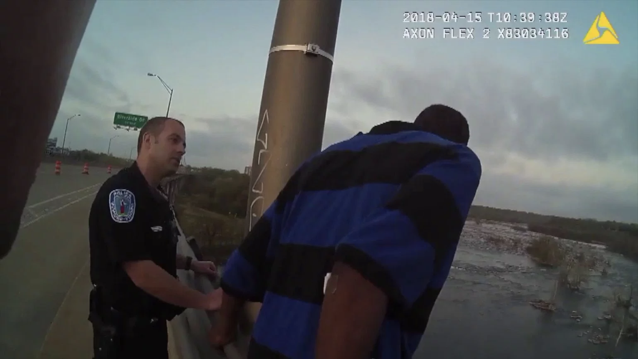 Officer Daniel Raines attempts to persuade a distraught man not to jump off the Robert E. Lee Bridge in Richmond, Va. (Photo: WTVR)