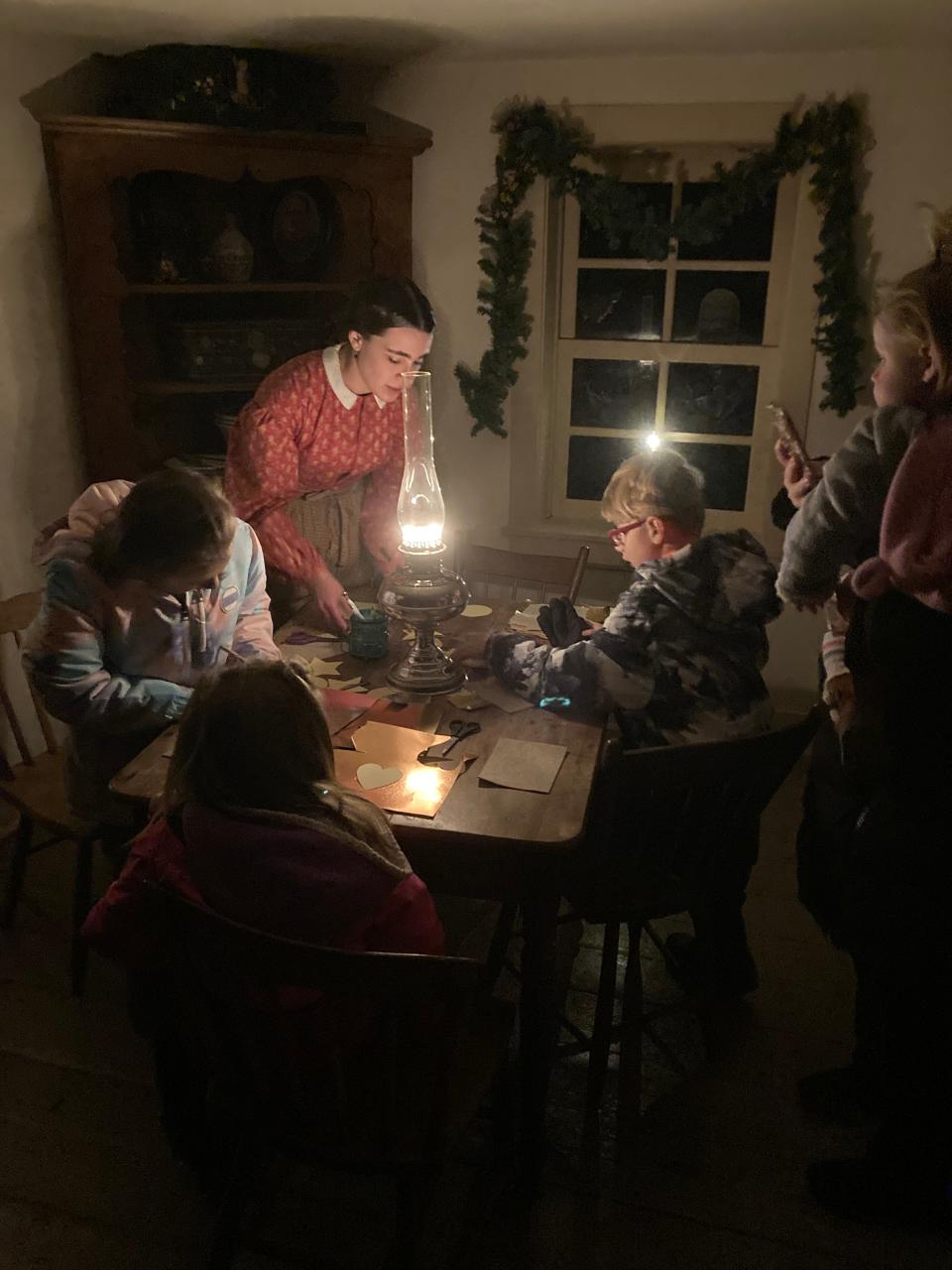 FILE - Visitors to the Kunze Cabin making ornaments at Pinecrest Historical Village in Manitowoc during Pinecrest Christmas in December 2022.