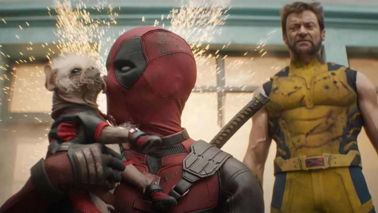  Dogpool licks Deadpool's face as Wolverine looks on in Marvel's Deadpool and Wolverine, the next Marvel Phase 5 movie. 