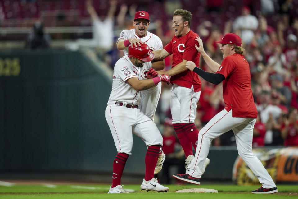 Cincinnati Reds' Christian Encarnacion-Strand, bottom left, celebrates with Spencer Steer, back, TJ Friedl, middle, and Andrew Abbott, right, after hitting a game winning RBI single during the ninth inning of a baseball game against the Seattle Mariners in Cincinnati, Tuesday, Sept. 5, 2023. (AP Photo/Aaron Doster)