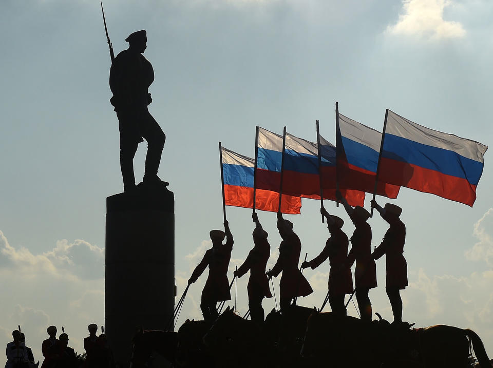 <p>Riders hold the Russian national flag next to a bronze statue of a Russian soldier in Moscow on August 22, 2016, during celebrations of the National Flag Day. Russia marks the 25th anniversary of the abortive 1991 coup against then Soviet president Mikhail Gorbachev. August 22, 1991, when Russia’s flag was raised atop the Russian White House instead of the Soviet one was declared as Russia’s Flag Day. (Vasily Maximov/AFP/Getty Images) </p>