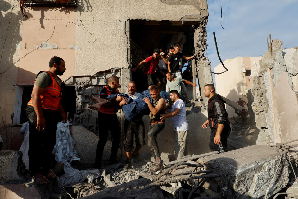 Palestinians carry a casualty from under the rubble of a house destroyed by Israeli strikes in Khan Younis.