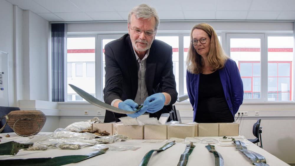  Two people inspect a collection of artifacts. . 