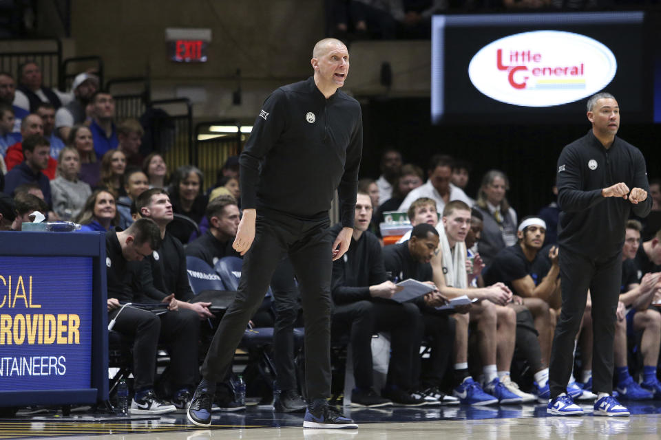 BYU coach Mark Pope, center, reacts during the second half of an NCAA college basketball game against West Virginia, Saturday, Feb. 3, 2024, in Morgantown, W.Va. (AP Photo/Kathleen Batten)