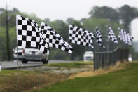 Checkered flags line a street outside Darlington Raceway Sunday, May 17, 2020, in Darlington, S.C. NASCAR, which has been idle since March 8 because of the coronavirus pandemic, makes its return with the Real Heroes 400 Nascar Cup Series auto race Sunday. (AP Photo/Brynn Anderson)