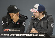 Mercedes driver Lewis Hamilton, left, of Britain, talks with McLaren driver Fernando Alonso, of Spain, during a news conference for the Formula One U.S. Grand Prix auto race at the Circuit of the Americas, Thursday, Oct. 18, 2018, in Austin, Texas. (AP Photo/Darren Abate)