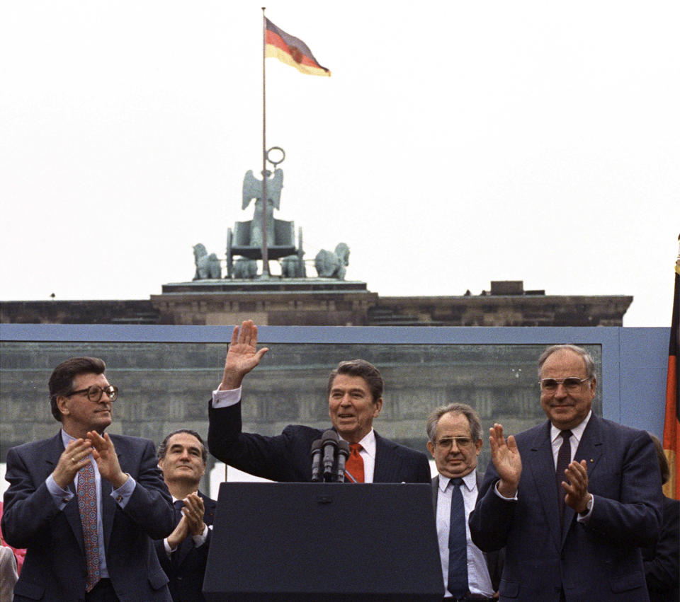 FILE- President Reagan acknowledges the crowd after his speech in front of the Brandenburg Gate in West Berlin on June 12, 1987, where he said "Mr. Gorbachev, tear down this wall!" As most Republican White House hopefuls gather Wednesday at Reagan’s presidential library for a debate, expect to hear more homages to the “Great Communicator.” (AP Photo/Ira Schwartz, File)