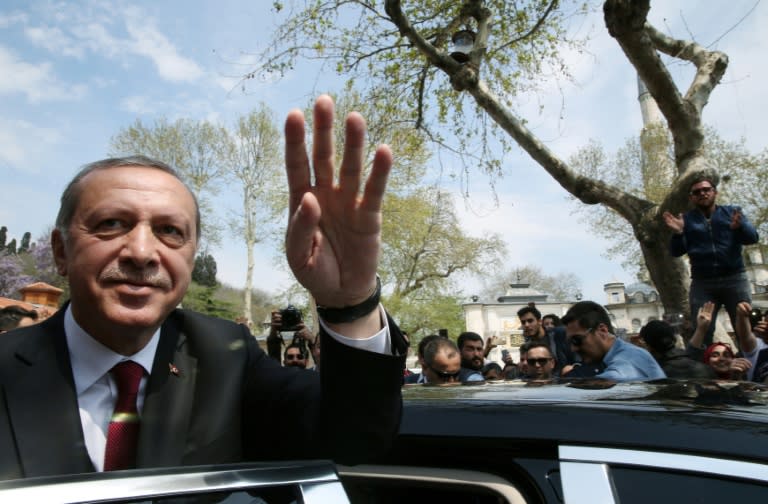 Turkish President Recep Tayyip Erdogan (L) greeting supporters during his visit to the Eyup Sultan Mosque in Istanbul the day after his victory in a national referendum on April 17, 2017