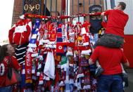 Men put a scarf on the Shankly gates before a memorial service to mark the 25th anniversary of the Hillsborough disaster at Anfield in Liverpool, northern England April 15, 2014. REUTERS/Darren Staples