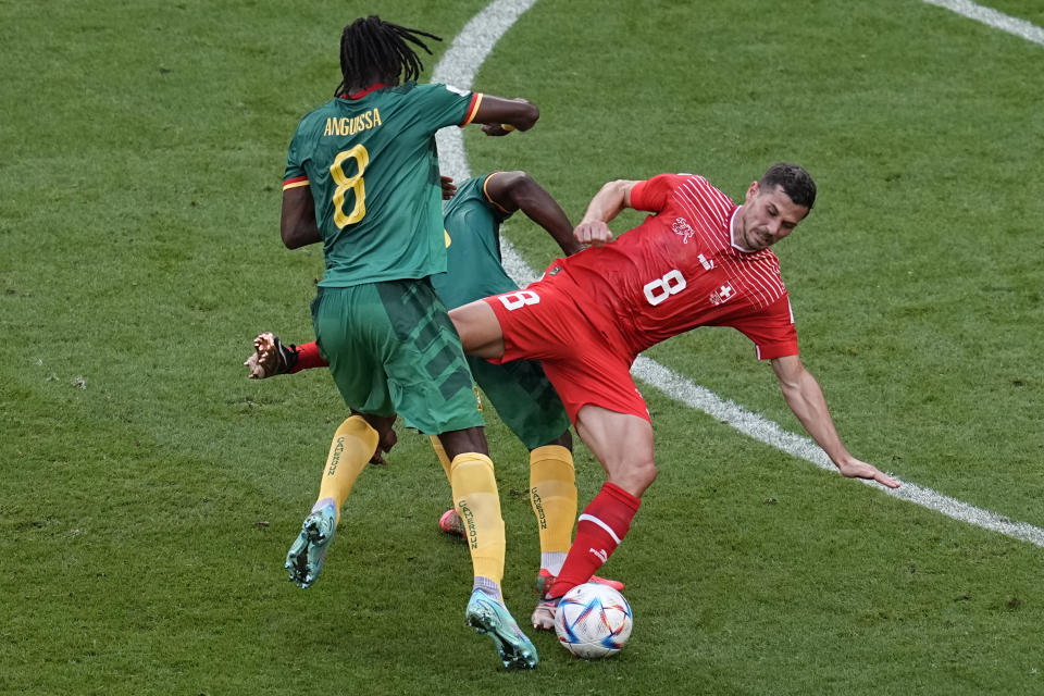 Switzerland's Remo Freuler is sandwiched during the World Cup group G soccer match between Switzerland and Cameroon, at the Al Janoub Stadium in Al Wakrah, Qatar, Thursday, Nov. 24, 2022. (AP Photo/Ebrahim Noroozi)