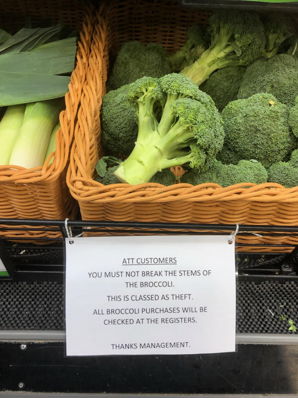 Basket of broccoli in supermarket with a sign warning customers not to break stems off