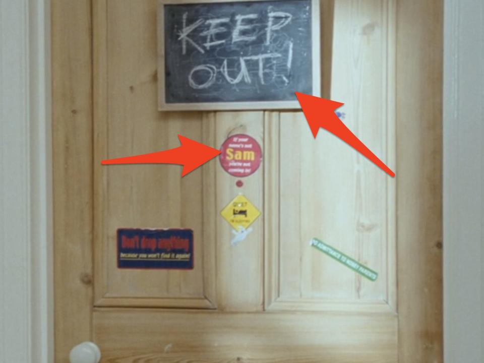 arrows pointing to stickers and a chalkboard on sams door in love actually