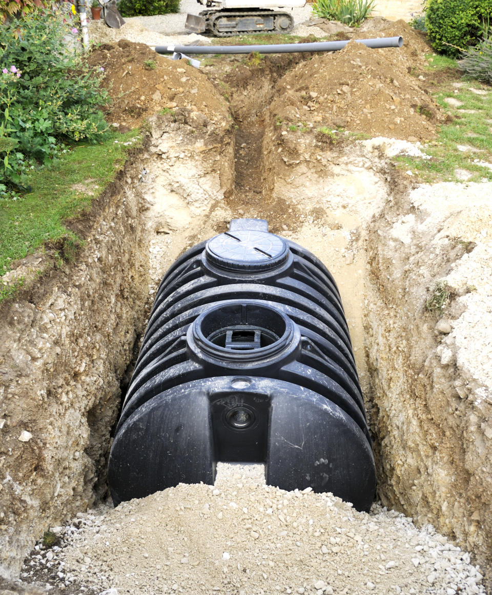 septic tank being buried in the backyard of someone's house