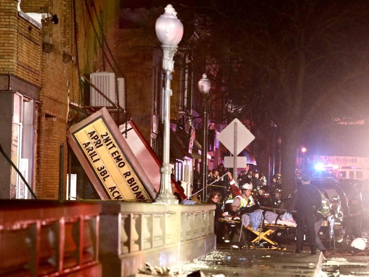 Emergency response workers remove injured concertgoers from the Apollo Theatre Friday night, March 31, 2023, in downtown Belvidere. The venue's roof collapsed during a severe storm with heavy rains and high winds.