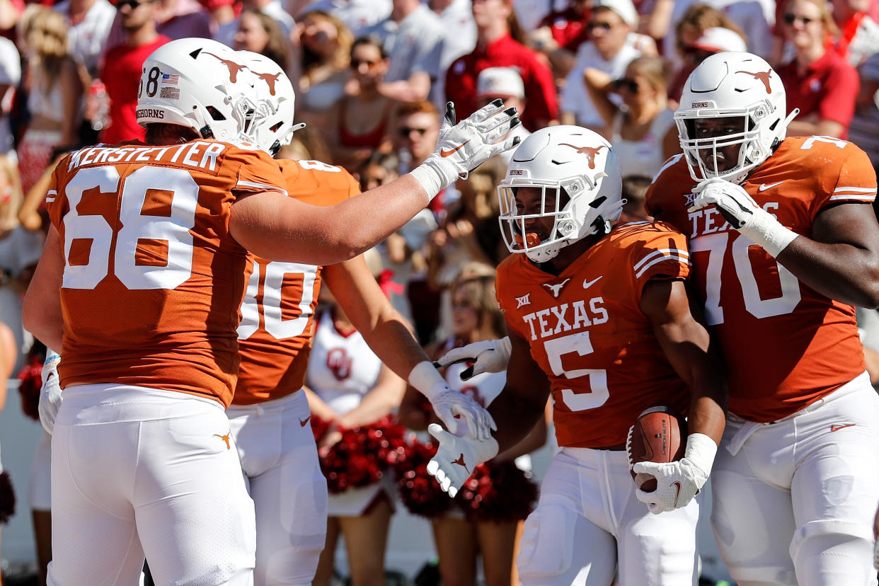 DALLAS, TEXAS - OCTOBER 09: Bijan Robinson #5 of the Texas Longhorns is congratulated after a touchdown run in the first quarter against the Oklahoma Sooners during the 2021 AT&T Red River Showdown at Cotton Bowl on October 09, 2021 in Dallas, Texas. (Photo by Tim Warner/Getty Images)