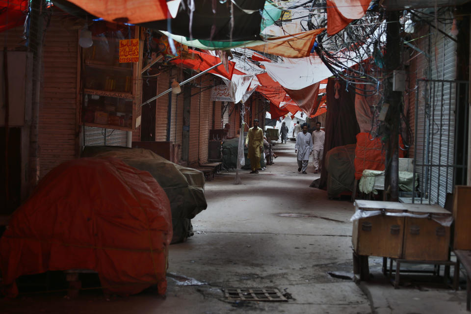 People walk through a main market which is closed due to a strike in Rawalpindi, Pakistan, Saturday, July 13, 2019. Pakistani traders have largely kept their business shut across the country against the new sales tax regime in the first budget of the new government they and opposition parties said came on the diktat of International Monetary Fund in turn of a $6bn bailout package. (AP Photo/Anjum Naveed)