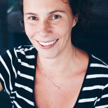 A selfie of a woman wearing a stripped shirt.