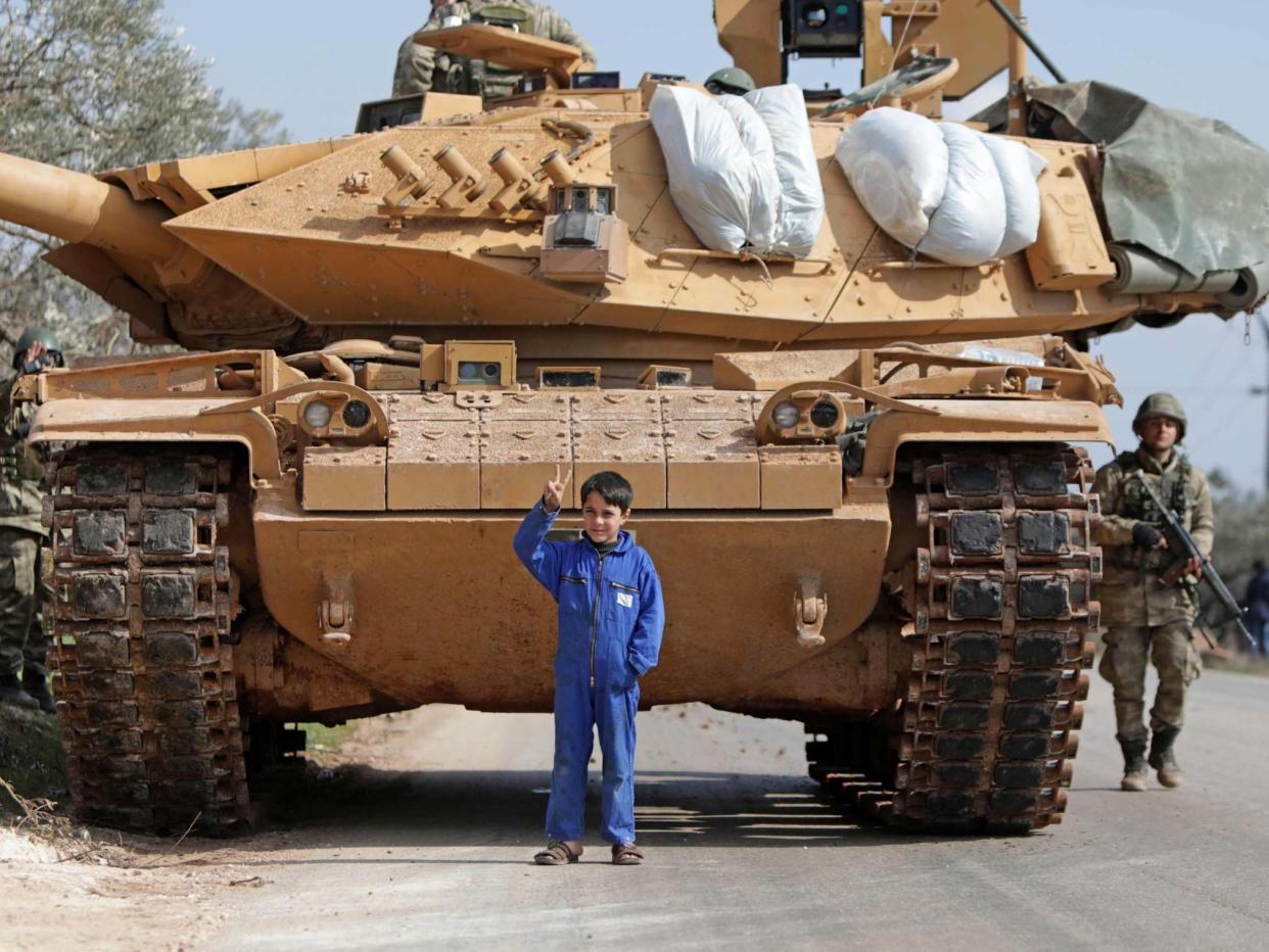 A Syrian boy stands in front of a Turkish military vehicle east of Idlib city in northwestern Syria on February 20, 2020: AFP via Getty